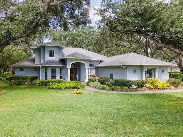12002 Hope Ln, Tampa, FL 33618 - view of front of property featuring stucco siding, a front yard, and roof with shingles