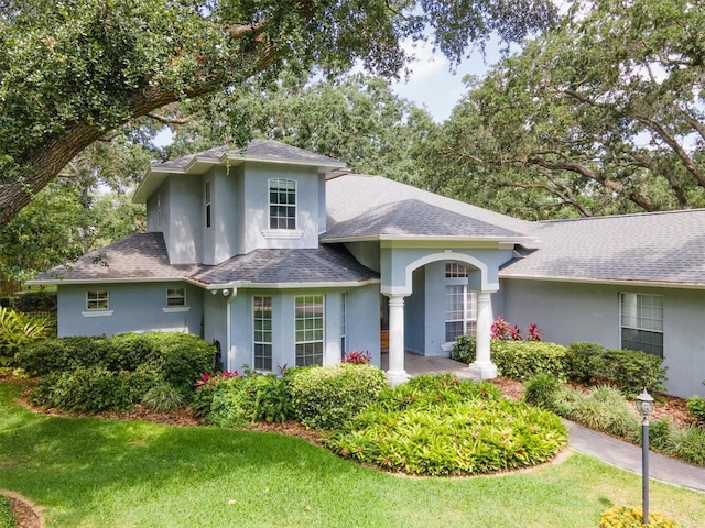 12002 Hope Ln, Tampa, FL 33618 - view of front of property featuring stucco siding, a shingled roof, and a front lawn