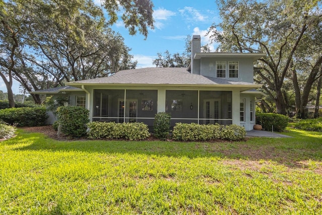 12002 Hope Ln, Tampa, FL 33618 - back of property with a chimney, a sunroom, a yard, and stucco siding
