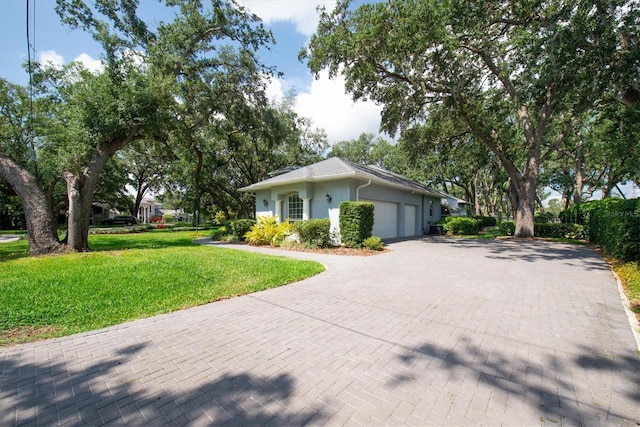 12002 Hope Ln, Tampa, FL 33618 - view of side of home featuring an attached garage, a yard, decorative driveway, and stucco siding