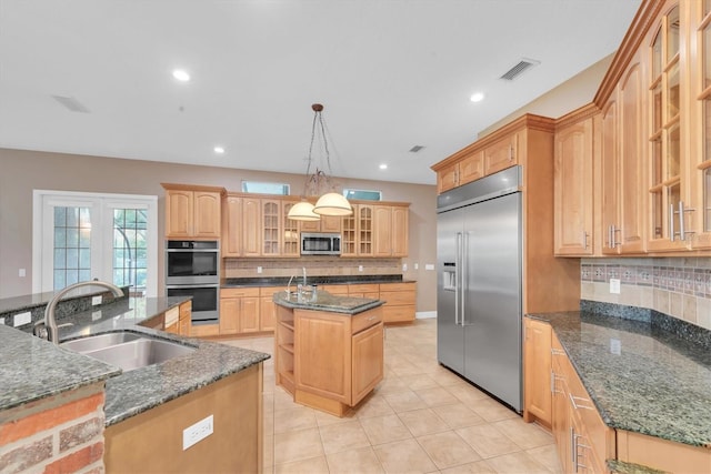12002 Hope Ln, Tampa, FL 33618 - kitchen with appliances with stainless steel finishes, a kitchen island with sink, a sink, decorative backsplash, and light tile patterned flooring