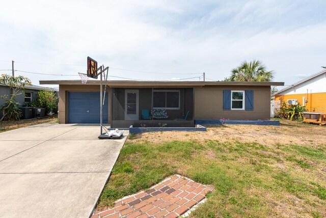 8305 75th Pl, Seminole, FL 33777 - ranch-style house featuring an attached garage, concrete driveway, a front lawn, central AC, and a sunroom