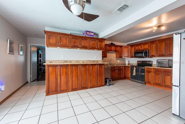 8305 75th Pl, Seminole, FL 33777 - kitchen featuring stainless steel appliances, a ceiling fan, brown cabinets, light stone countertops, and beamed ceiling
