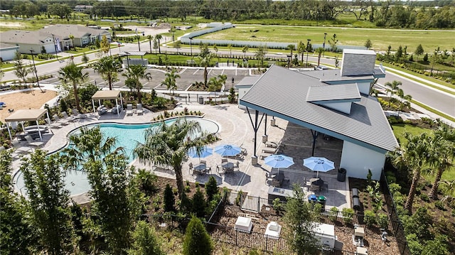 aerial view of a pool area and a tree filled landscape