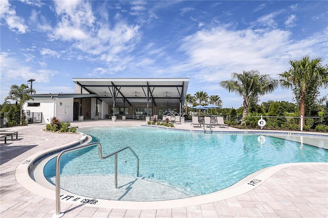 community pool featuring fence and a patio area