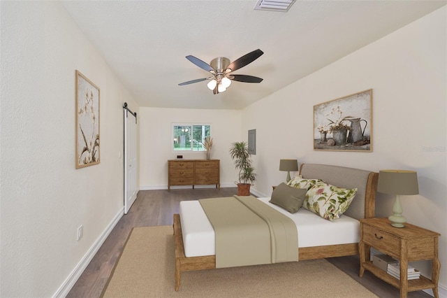 10922 Park Dr, Riverview, FL 33569 - bedroom featuring a barn door, wood finished floors, and ceiling fan