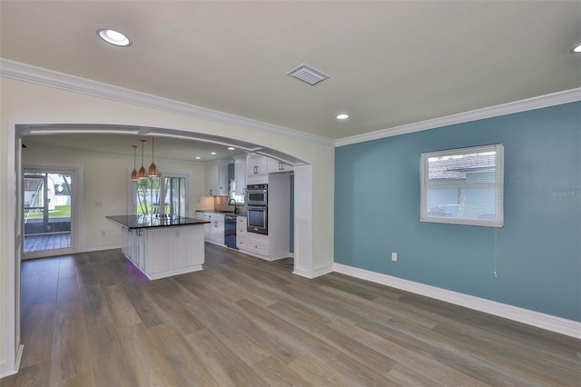 10922 Park Dr, Riverview, FL 33569 - kitchen featuring arched walkways, white cabinets, dark countertops, crown molding, and stainless steel double oven