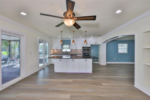 10922 Park Dr, Riverview, FL 33569 - kitchen featuring dark countertops, white cabinetry, multiple ovens, arched walkways, and a ceiling fan