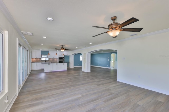 10922 Park Dr, Riverview, FL 33569 - unfurnished living room with ceiling fan, arched walkways, ornamental molding, recessed lighting, and light wood finished floors