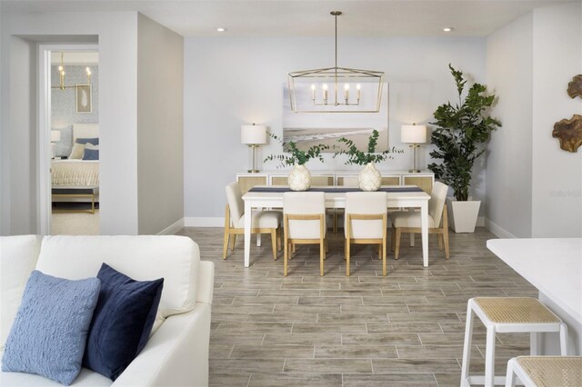 dining space featuring a chandelier, baseboards, wood finish floors, and recessed lighting