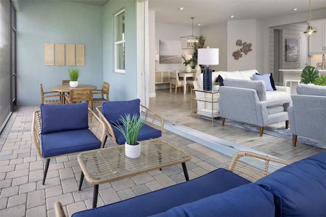 living area featuring a chandelier, recessed lighting, and baseboards