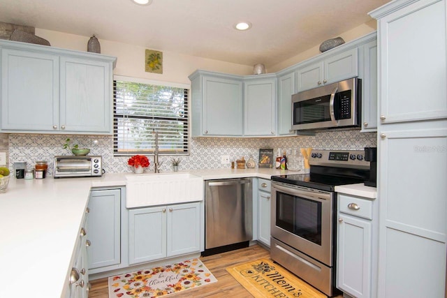 351 Hancock St, Dunedin, FL 34698 - kitchen featuring stainless steel appliances, light wood finished floors, tasteful backsplash, light countertops, and recessed lighting
