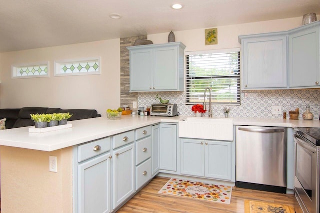 351 Hancock St, Dunedin, FL 34698 - kitchen with stainless steel appliances, a peninsula, light wood-style floors, open floor plan, and decorative backsplash