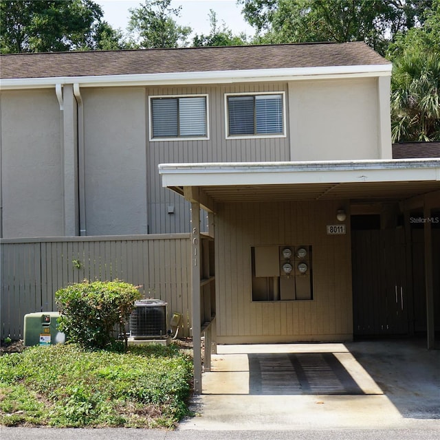 8011 Peach Dr Unit 103, Tampa, FL 33637 - view of front of home with central AC, roof with shingles, and fence