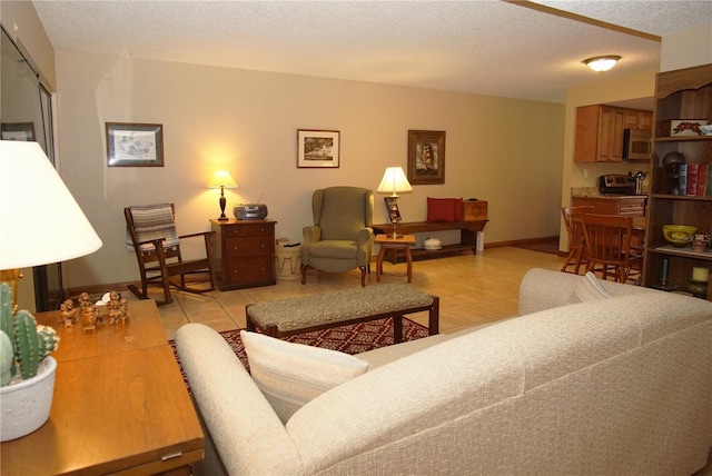 8011 Peach Dr Unit 103, Tampa, FL 33637 - living area featuring light tile patterned floors, baseboards, and a textured ceiling