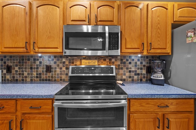 18631 Le Dauphine Pl, Lutz, FL 33558 - kitchen featuring appliances with stainless steel finishes, tasteful backsplash, and brown cabinets