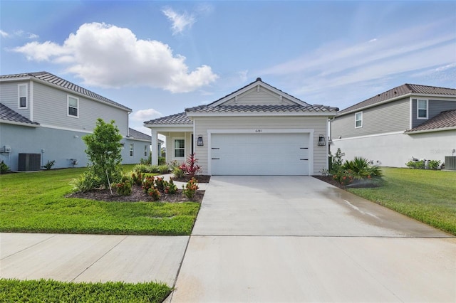 view of front of house with a front yard, a garage, central air condition unit, and concrete driveway