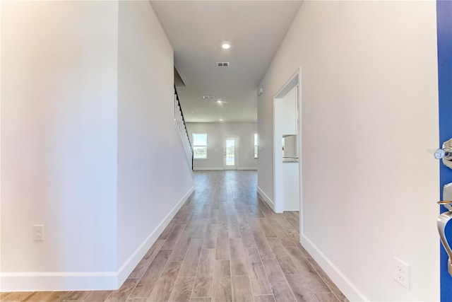 hallway featuring light wood-style floors and baseboards