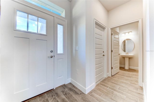 foyer featuring baseboards and light wood-style floors