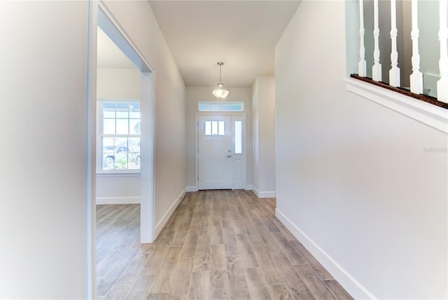 doorway featuring light wood finished floors and baseboards