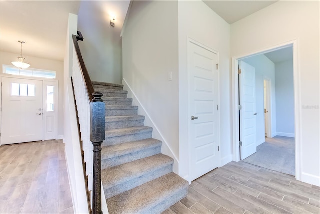staircase featuring wood finished floors and baseboards