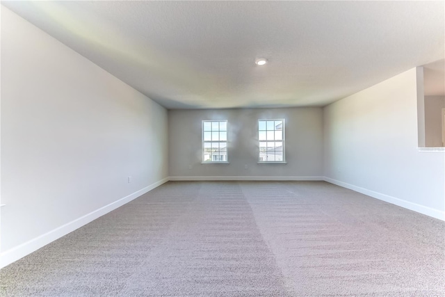 carpeted empty room featuring baseboards
