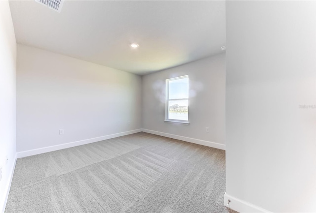 carpeted empty room featuring baseboards and recessed lighting