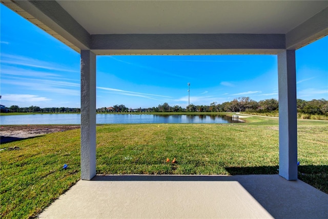 view of grassy yard featuring a water view and a patio area