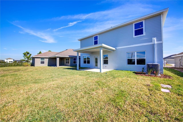 rear view of house featuring central air condition unit, a patio, a yard, and stucco siding