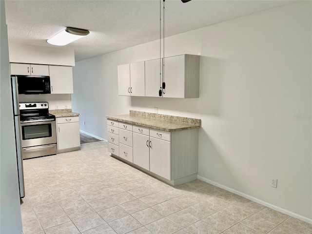 2293 Swedish Dr Unit 11, Clearwater, FL 33763 - kitchen with electric stove, black microwave, baseboards, white cabinetry, and a textured ceiling