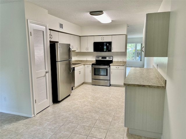 2293 Swedish Dr Unit 11, Clearwater, FL 33763 - kitchen with appliances with stainless steel finishes, a textured ceiling, light countertops, light tile patterned floors, and white cabinets