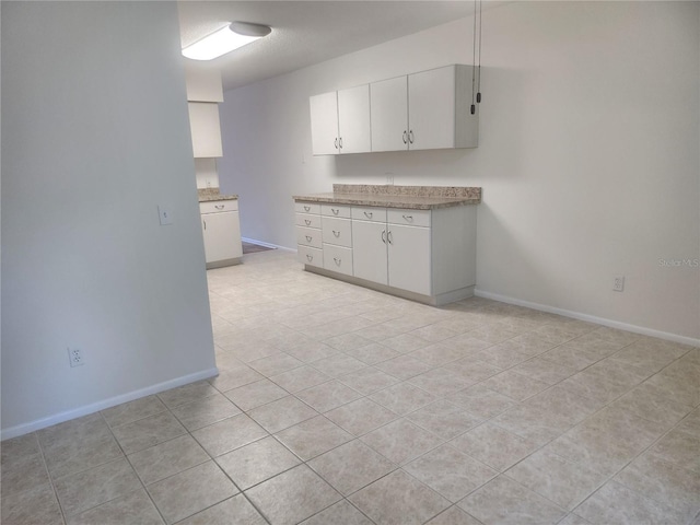 2293 Swedish Dr Unit 11, Clearwater, FL 33763 - kitchen with light tile patterned floors, white cabinets, and baseboards