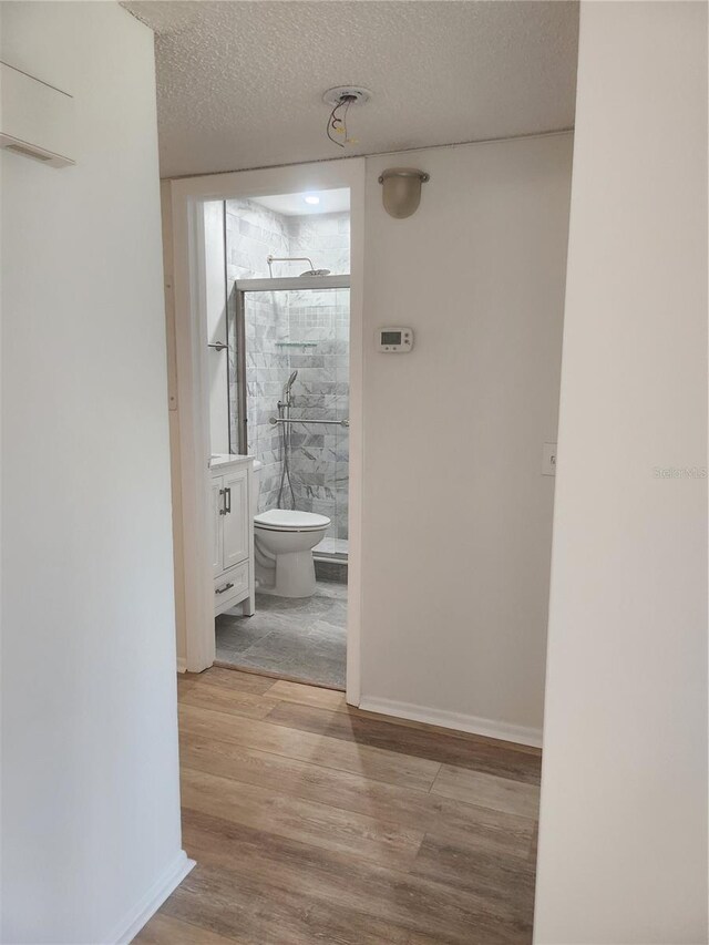 2293 Swedish Dr Unit 11, Clearwater, FL 33763 - hall with wood finished floors, a textured ceiling, and baseboards