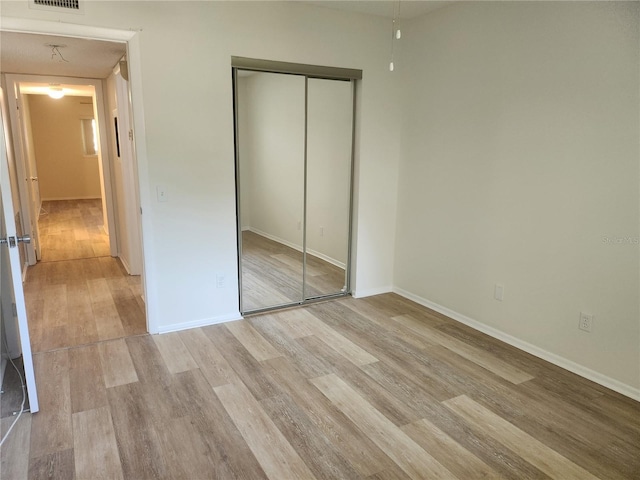 2293 Swedish Dr Unit 11, Clearwater, FL 33763 - unfurnished bedroom with light wood-style flooring, a closet, and baseboards