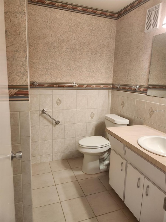 2293 Swedish Dr Unit 11, Clearwater, FL 33763 - half bath featuring tile walls, tile patterned flooring, vanity, and toilet