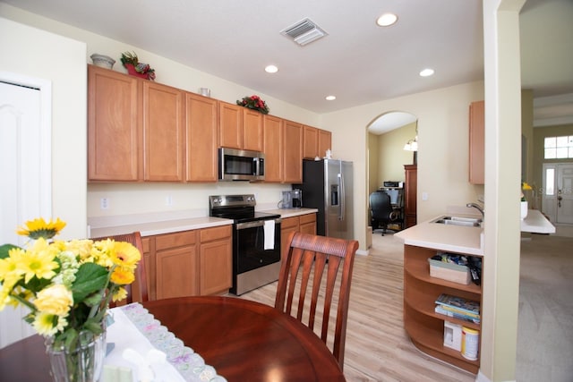 11021 Silver Dancer Dr, Riverview, FL 33579 - kitchen featuring stainless steel appliances, arched walkways, a sink, light countertops, and recessed lighting