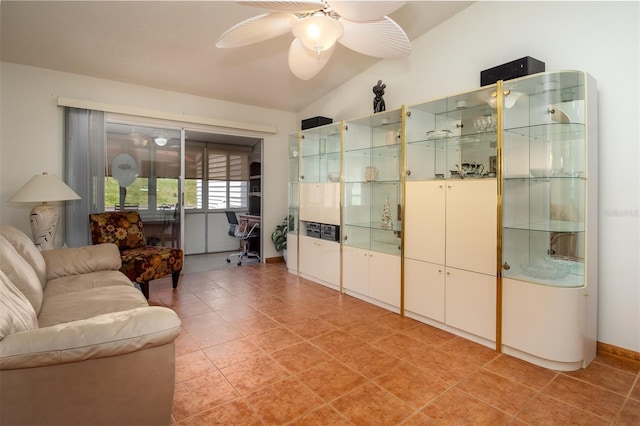 living area featuring ceiling fan, light tile patterned floors, and lofted ceiling