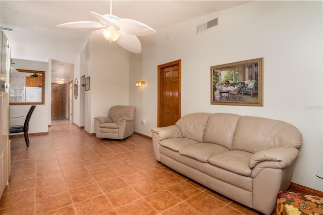 living room featuring lofted ceiling, ceiling fan, baseboards, and light tile patterned floors