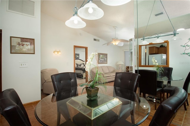 dining space with lofted ceiling, tile patterned flooring, and ceiling fan