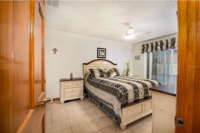 bedroom with a textured ceiling, light tile patterned floors, a ceiling fan, and access to outside