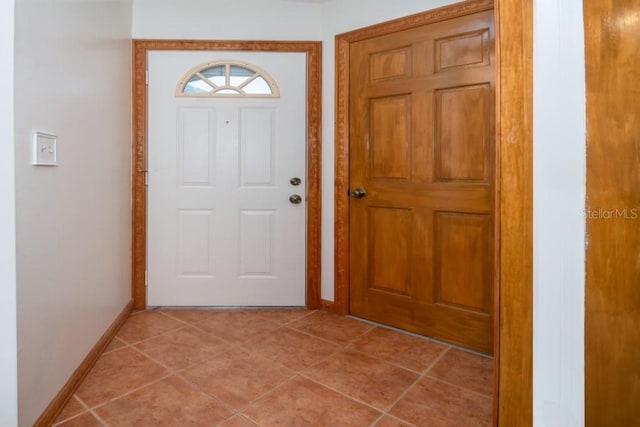 entryway with baseboards and light tile patterned floors
