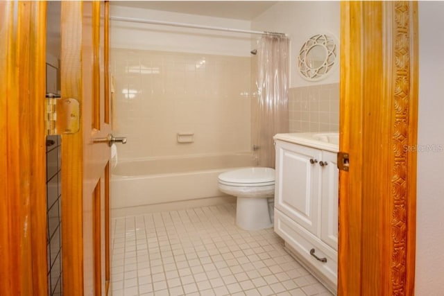 full bath with tile patterned flooring, toilet, shower / bath combo, vanity, and tile walls