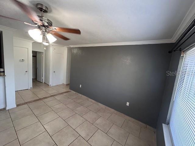 unfurnished bedroom with ornamental molding, light tile patterned floors, and ceiling fan