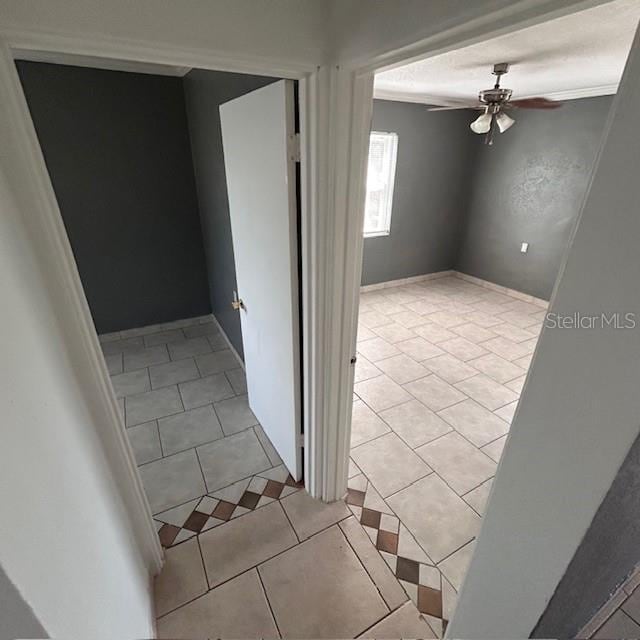 stairs featuring a ceiling fan and tile patterned floors