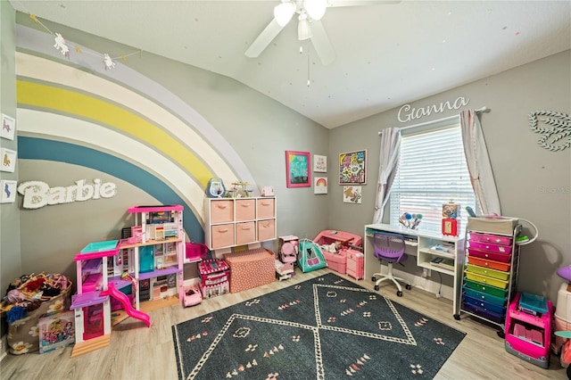 recreation room featuring wood finished floors, vaulted ceiling, and a ceiling fan
