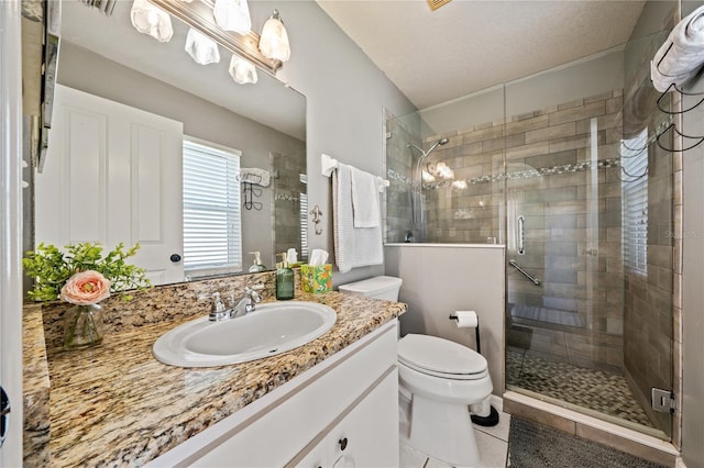bathroom featuring a shower stall, toilet, vanity, and tile patterned flooring