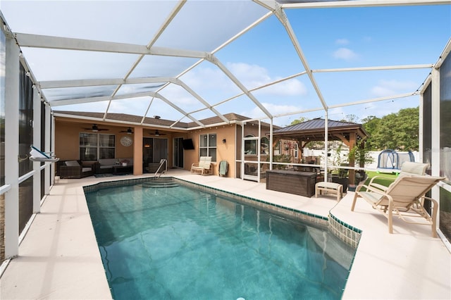 outdoor pool with outdoor lounge area, ceiling fan, a patio area, a gazebo, and a lanai