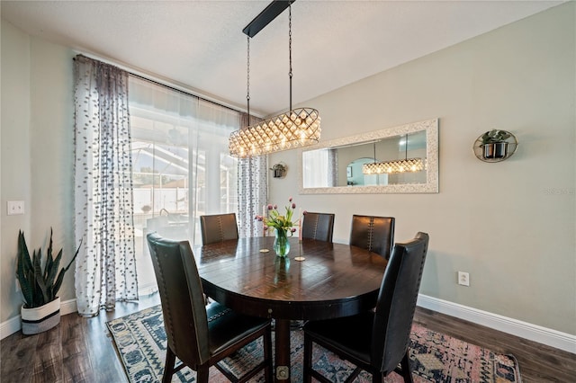 dining area with wood finished floors, baseboards, and a chandelier