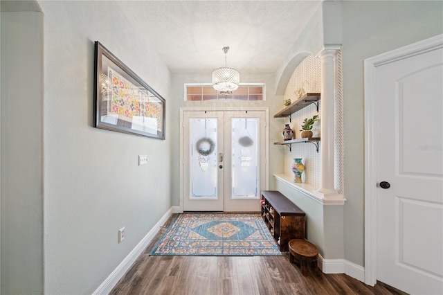 entrance foyer with baseboards, wood finished floors, a chandelier, french doors, and a textured ceiling