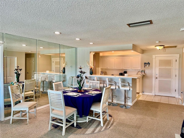 100 Bluff View Dr Unit 105C, Belleair Bluffs, FL 33770 - dining room with a textured ceiling, recessed lighting, light carpet, baseboards, and light tile patterned floors